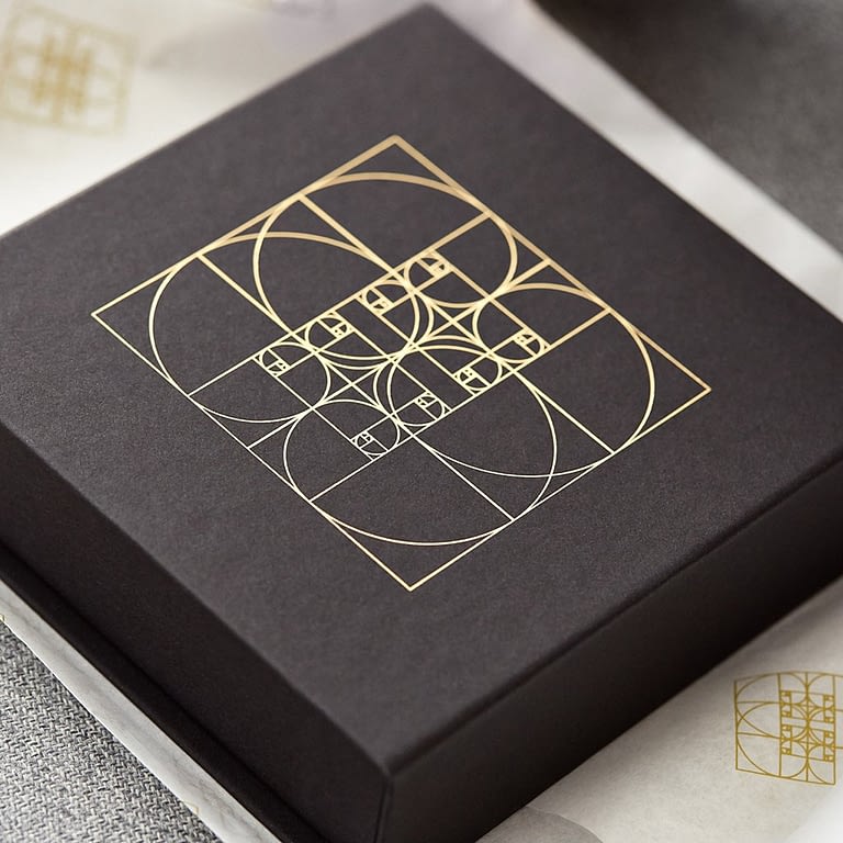 Die Box von Seelenkonferenz, gold-schimmerndes Logo auf der schwarzen edlen Box